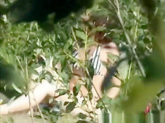 Naturist couple spied between the bushes having sex