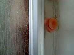 Peep her ride the sticky dildo in a shower