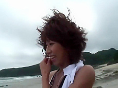 Randy brunette sucks guy's pole on the beach